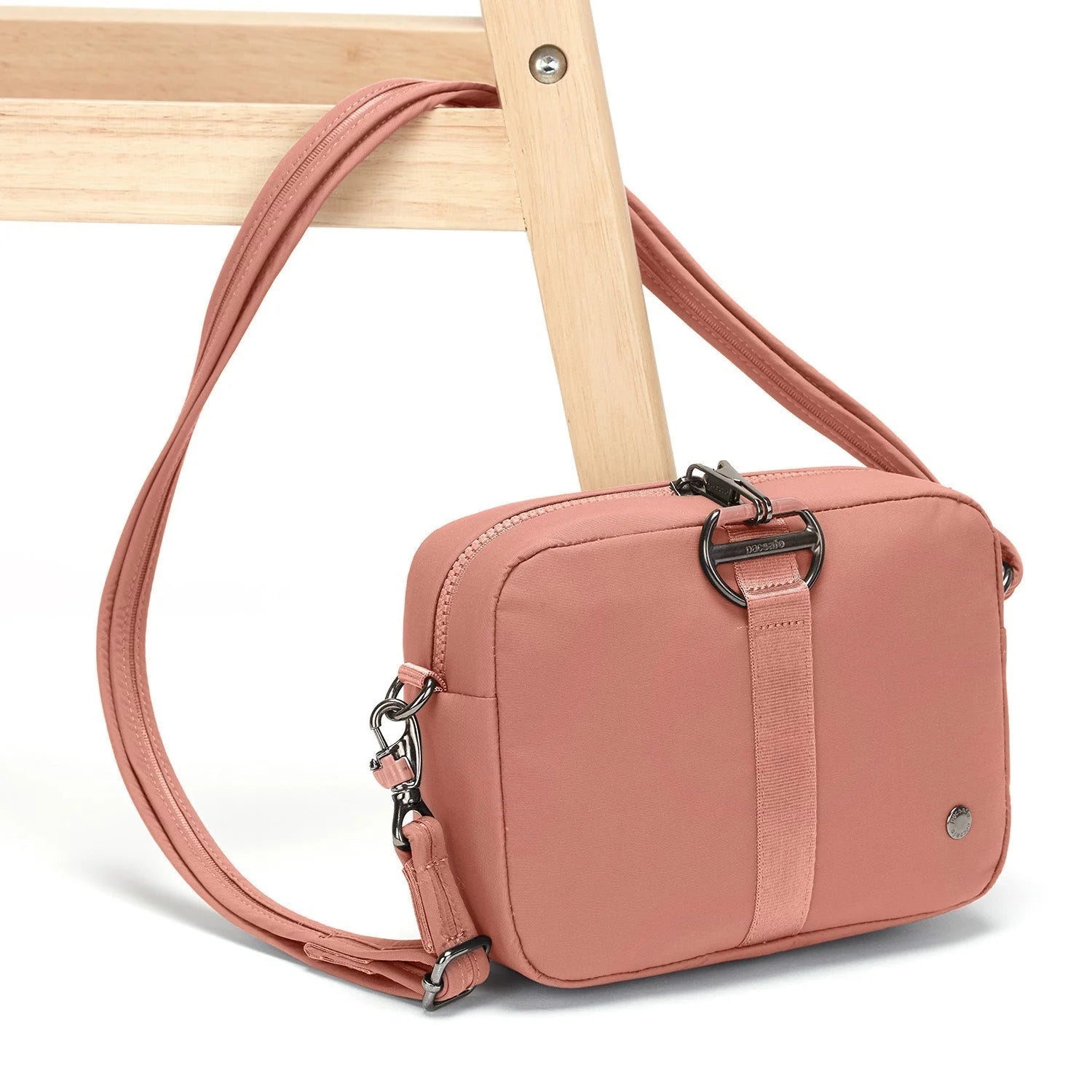 Rose Pacsafe Citysafe CX Square Crossbody Bag attached to chair leg
