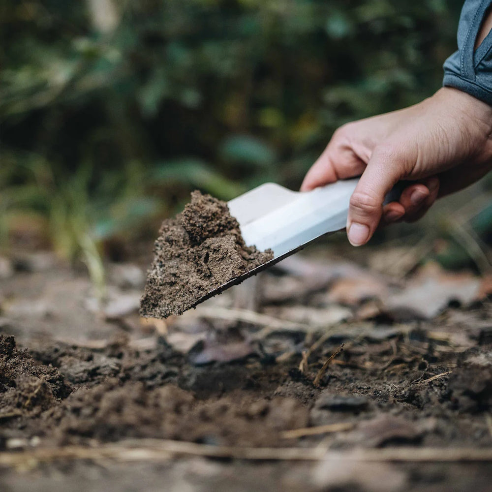 Man using Alton Goods Titanium Trowel to dig hole