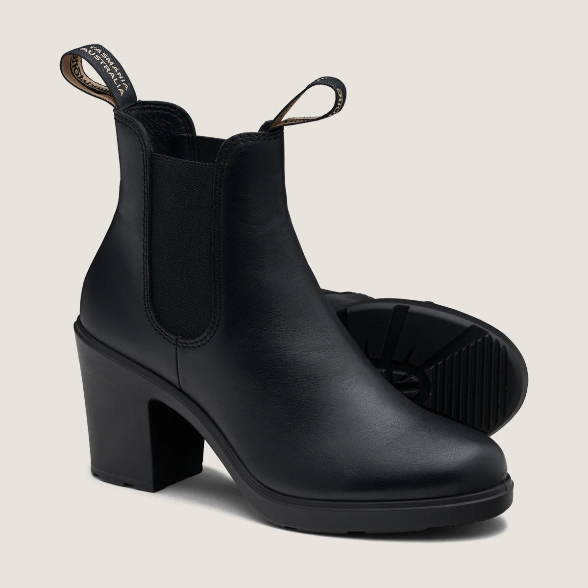 A pair of black, leather Blundstone boots with a heel and elastic sides.