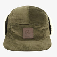 A green Swanndri Birchwood Sherpa Lined Cap with earflaps, featuring a leather badge on the front.