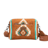 A tan Wrangler Maya Aztec crossbody bag with an Aztec pattern on the front panel, featuring a detachable and adjustable strap.