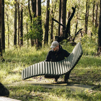 Man placing Alton Goods Insulated Sleeping Mat onto sheet