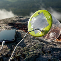 Luci Outdoor 2.0 Pro Solar Lantern on rock charging a phone