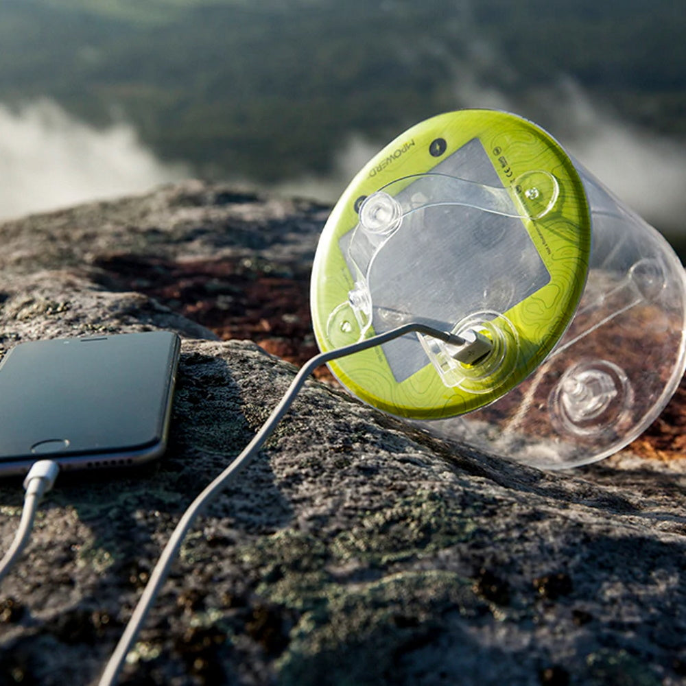 Luci Outdoor 2.0 Pro Solar Lantern on rock charging a phone