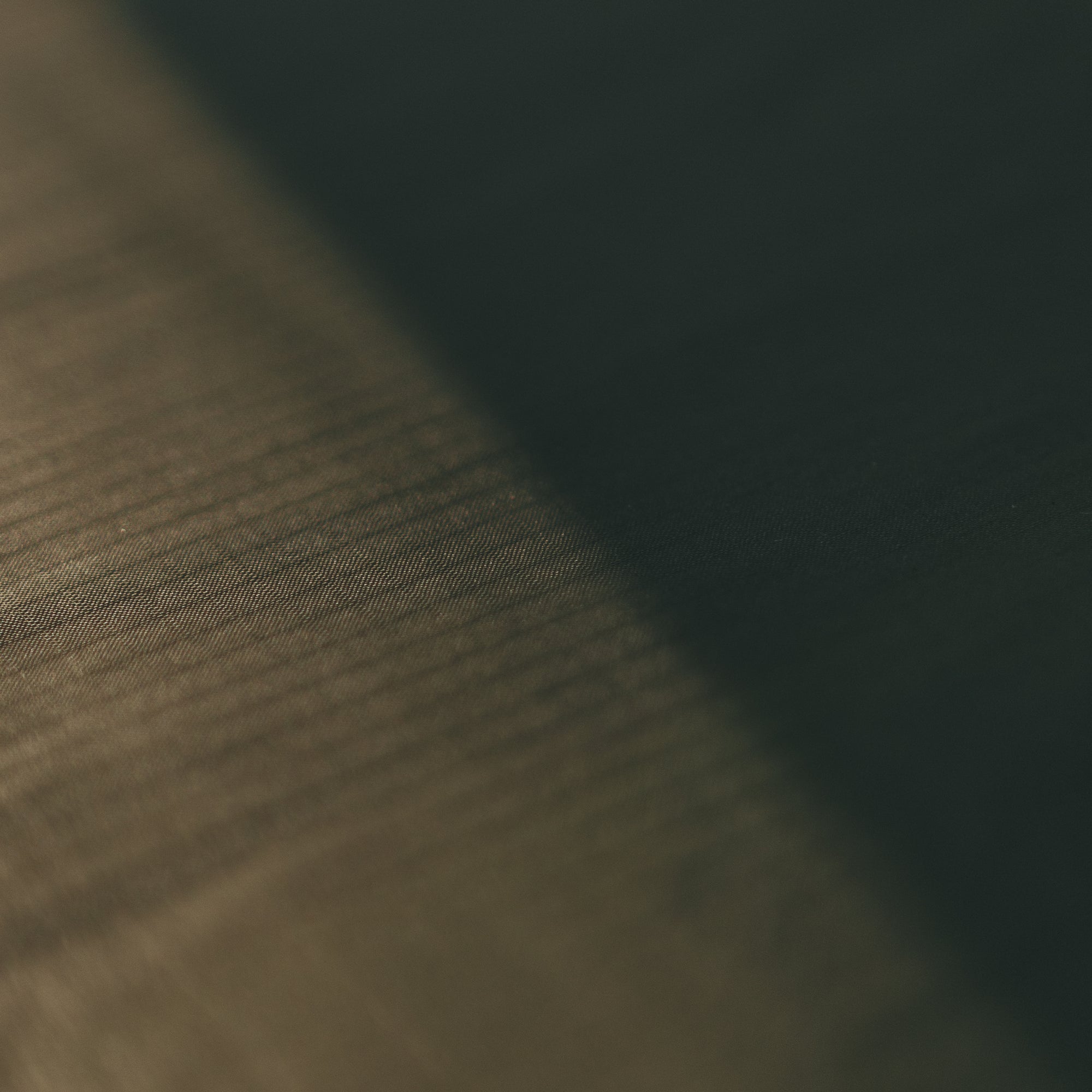 Close up of Alton Goods Ultralight Groundsheet fabric, half in sun, half in shade