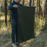 Man still folding Alton Goods Ultralight Groundsheet