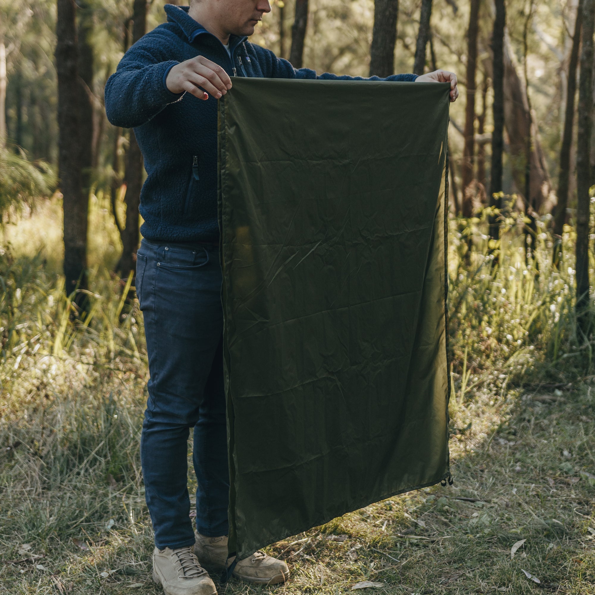 Man still folding Alton Goods Ultralight Groundsheet