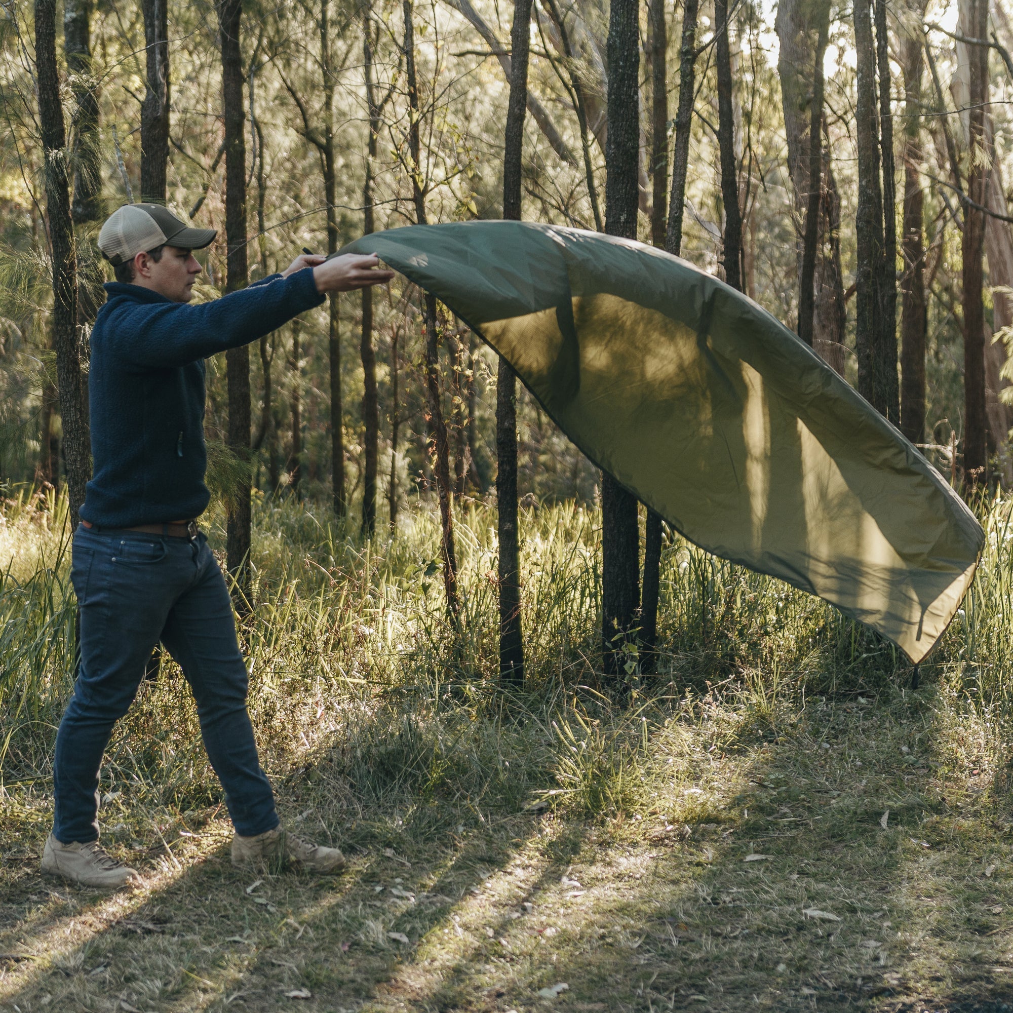 Man unrolling Alton Goods Ultralight Groundsheet