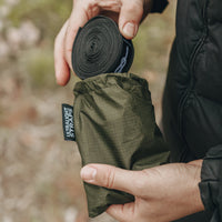 Man placing Alton Goods Ultralight Strap into bag