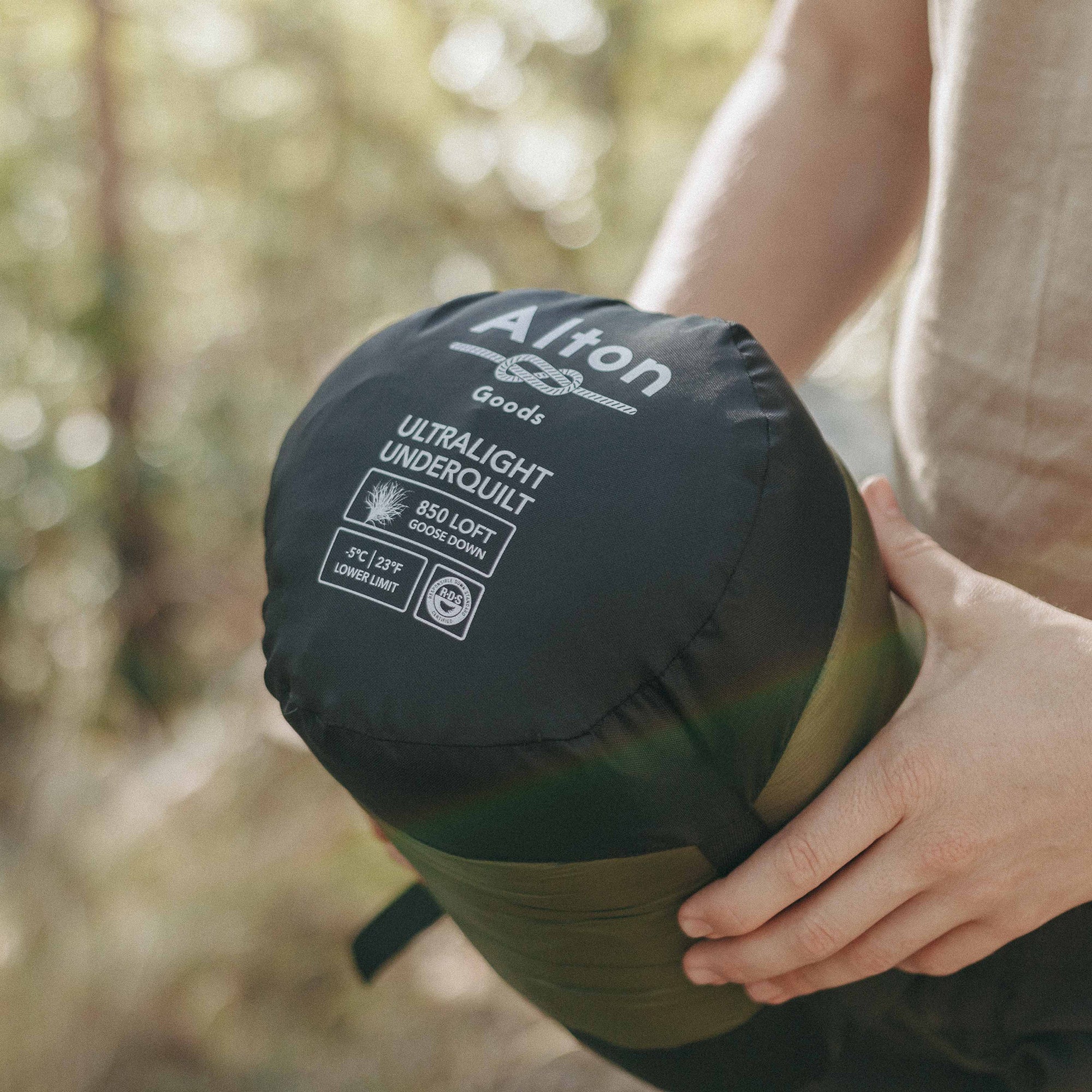 Man holding Alton Goods Ultralight Underquilt in bag