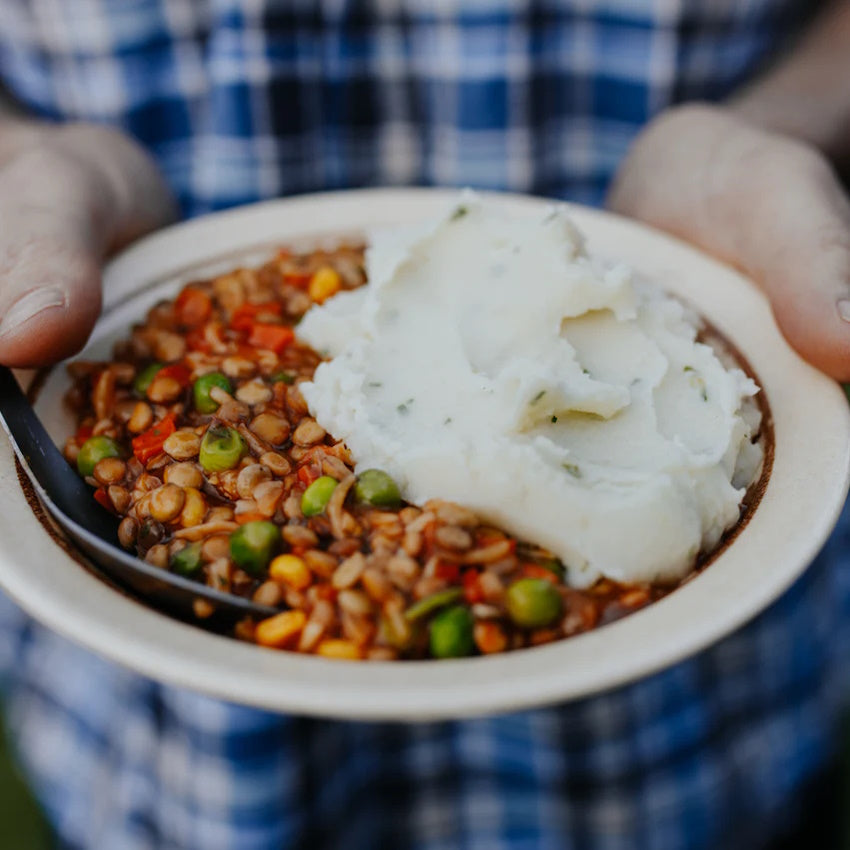 Man holding out Back Country Veggie Cottage Pie in bowl