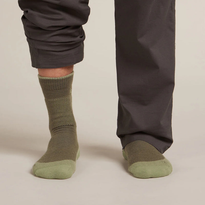 Person wearing Icebreaker green socks with dark pants
