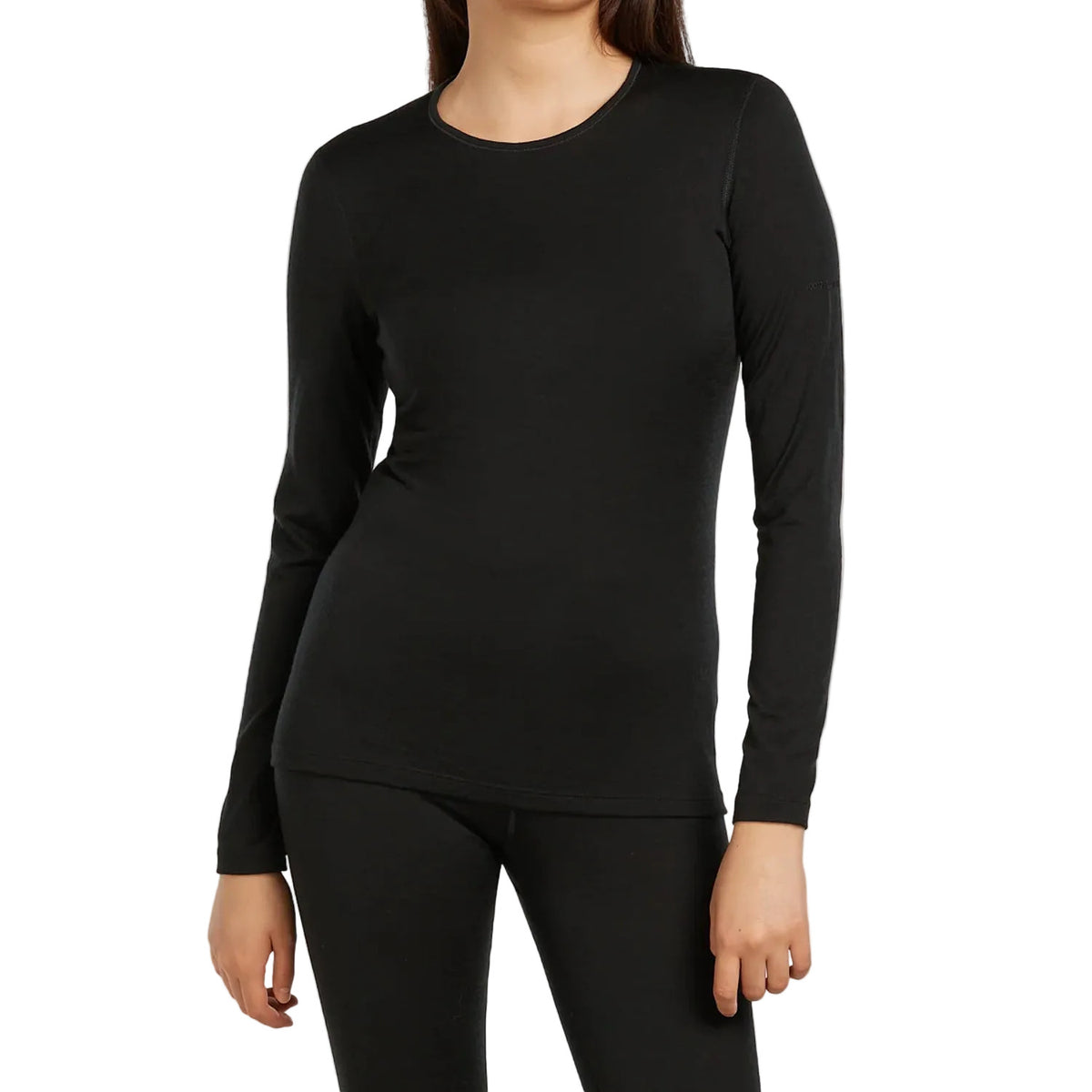 A woman wearing a Icebreaker black long sleeve crew neck top and black leggings.