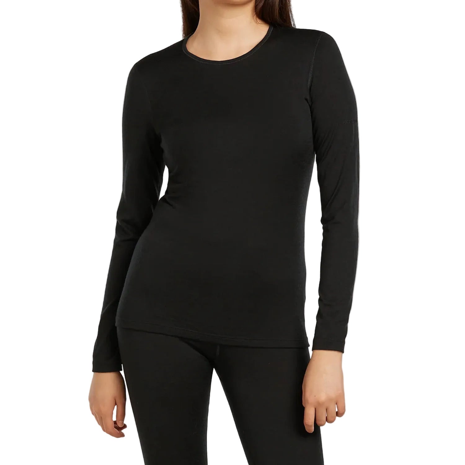 A woman wearing a Icebreaker black long sleeve crew neck top and black leggings.