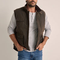 Man wearing a brown Driza-Bone Jumbuck vest over a grey shirt.