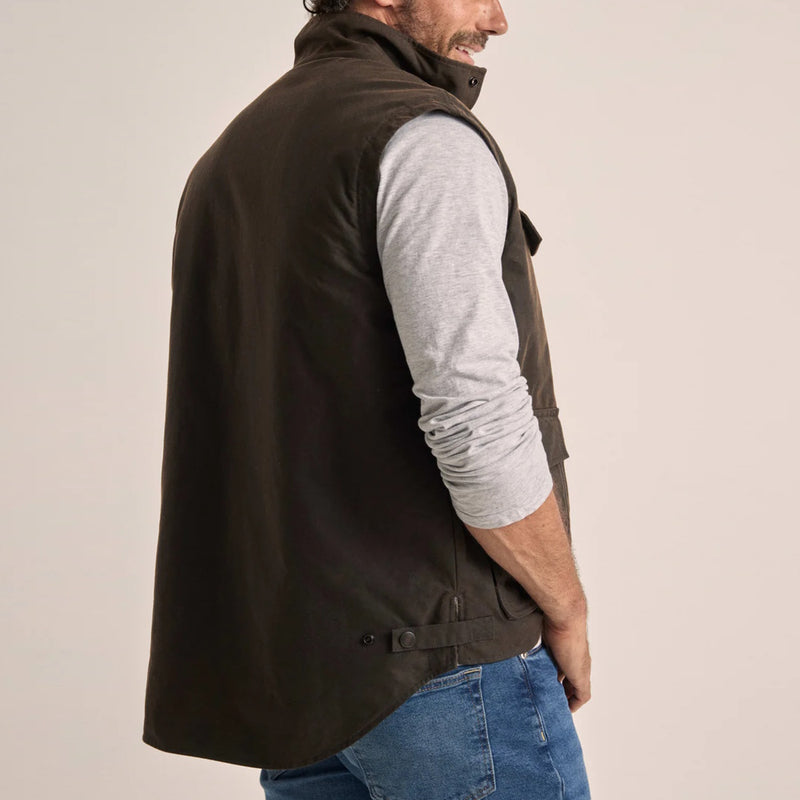 Back of man wearing a Driza-Bone brown vest over a grey shirt and blue jeans.