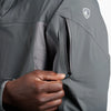 Person wearing a grey Kuhl jacket, focusing on the zipper area.