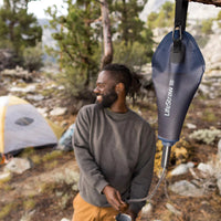 Man using LifeStraw Peak Series Compact Gravity Water Filter System 3L to fill cup