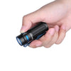 Thumb pressing power button on Olight Baton 3 Rechargeable 1200 Lumens Torch