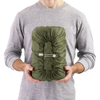 Man holding packed Sea to Summit green self inflating mat