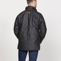 A man viewed from the back wearing a brown waxed cotton jacket
