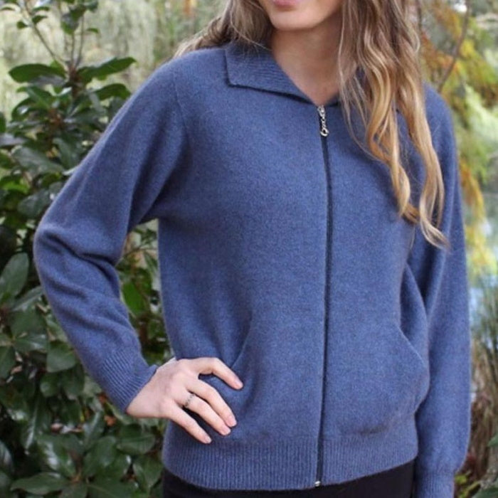 Female model wearing a light blue Lothlorian plain zip cardigan with hand on hip.