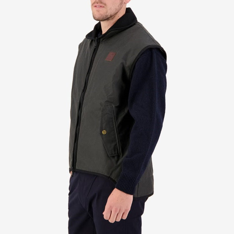 Front angle view of model wearing Swanndri Foxton Oilskin Vest in Brown